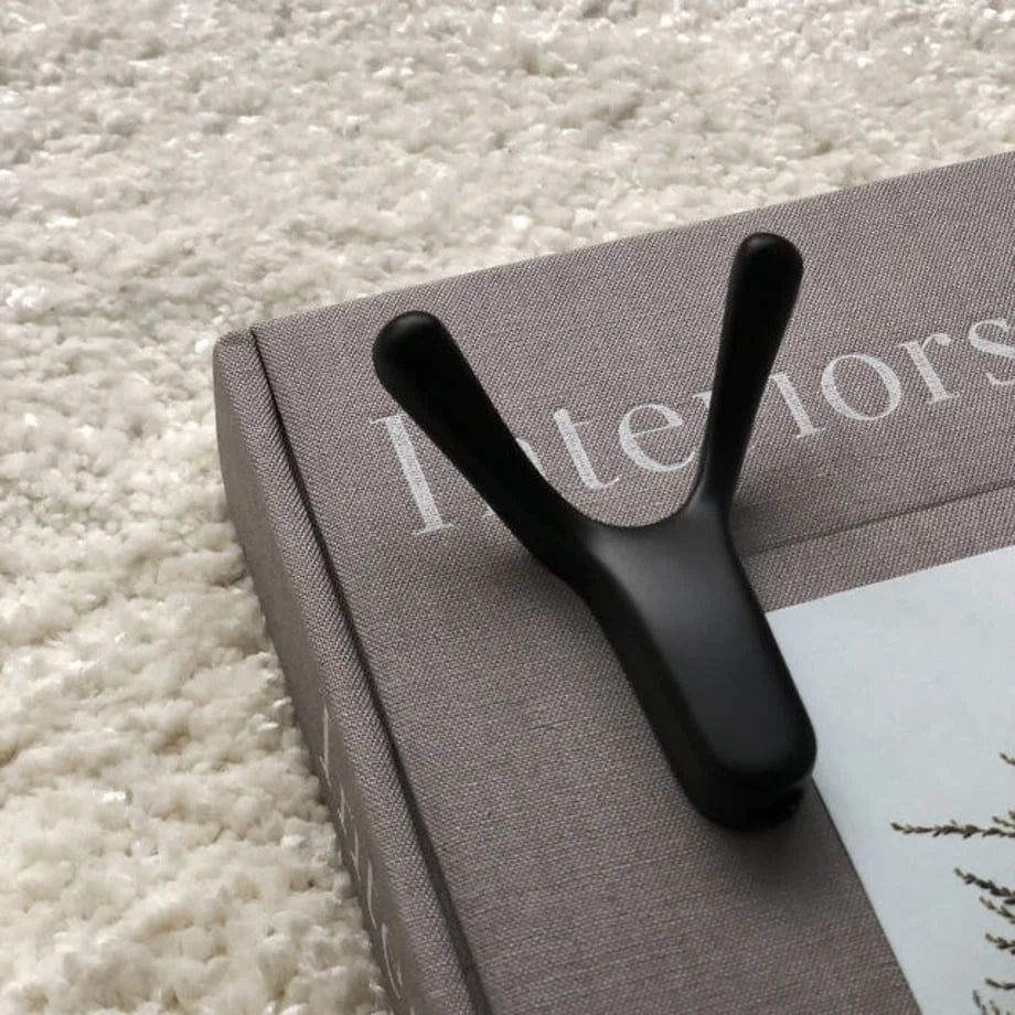 Variant Detail: Close-up of a single black Y-shaped metal hook on a book, showing its rounded edges - RoomDen