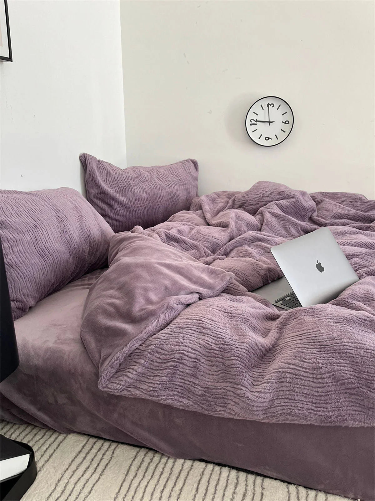 A Dusty Lavender ruched flannel fleece bedding set in a bright room with a laptop on the messy duvet. - RoomDen
