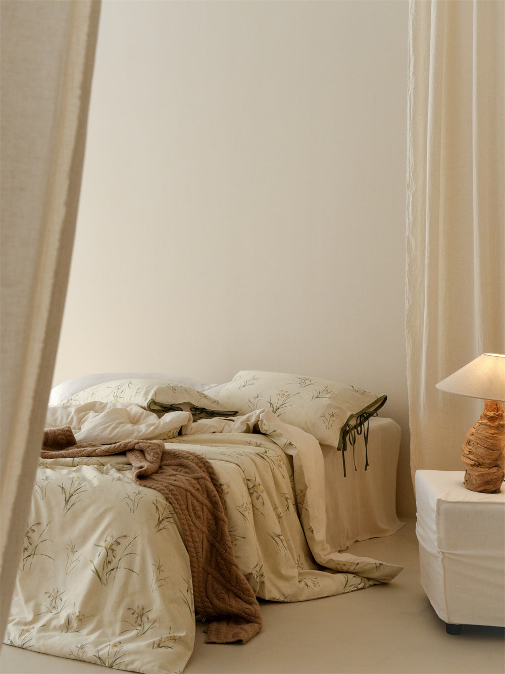 Stillgarden Meadow Sprig Cotton Linen Bedding Set – Angled view of the pale botanical bed beside a lamp - Roomden