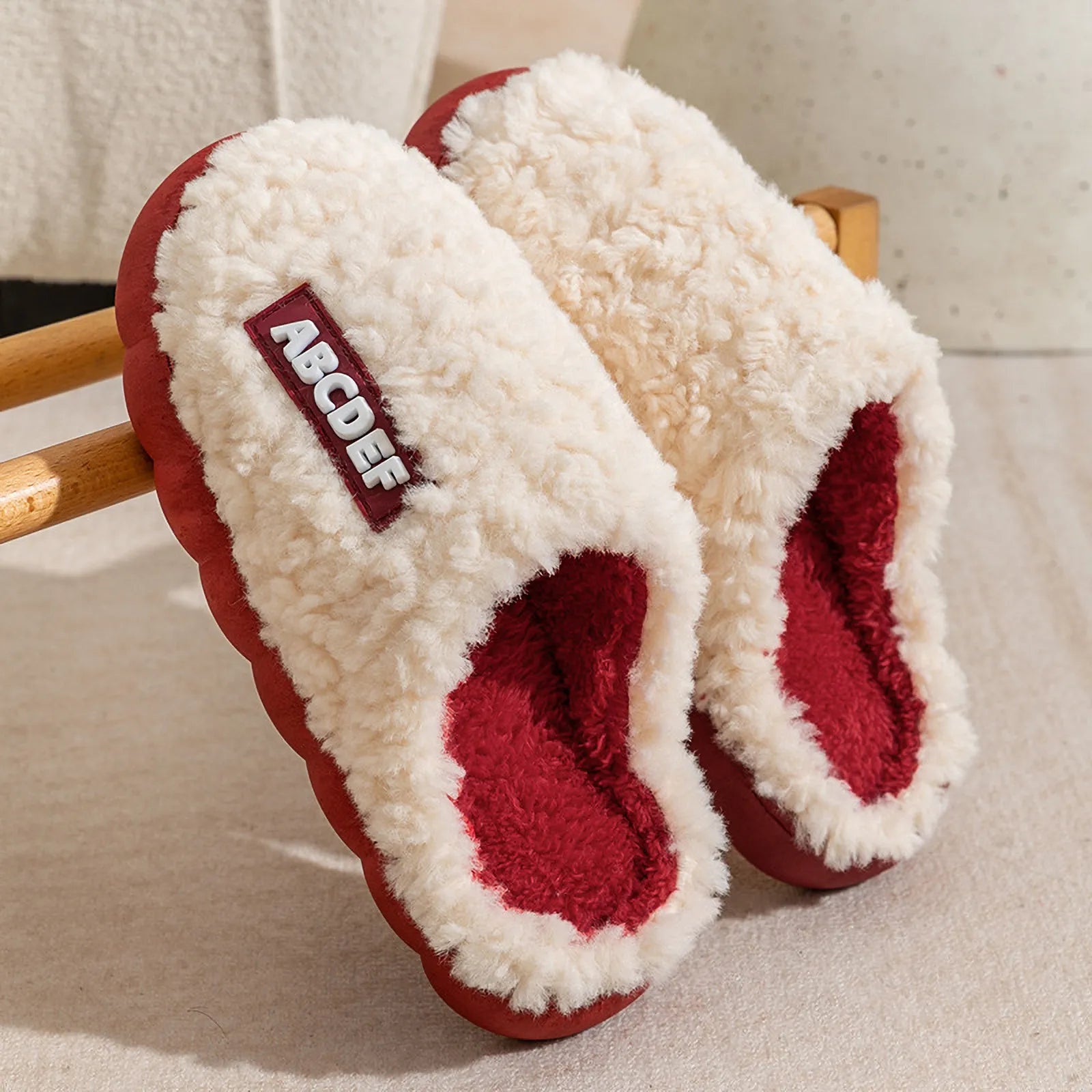White upper with red sole plush house slippers hanging on wooden rack - RoomDen