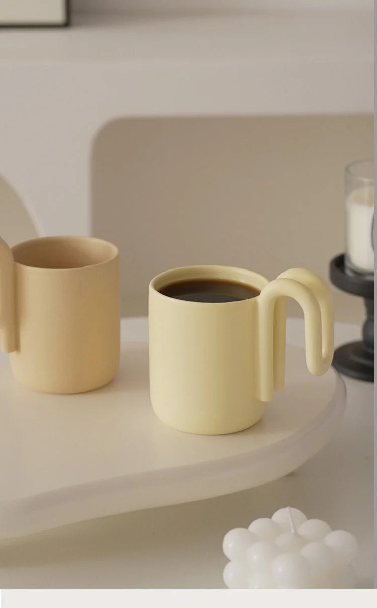Two Butter Yellow ceramic mugs on a minimalist beige tray, one filled with coffee - RoomDen
