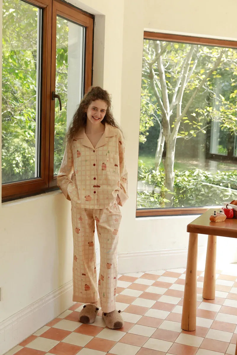 Lifestyle Shot of Model Standing in Dorm Style Room Wearing Capybara Pajamas