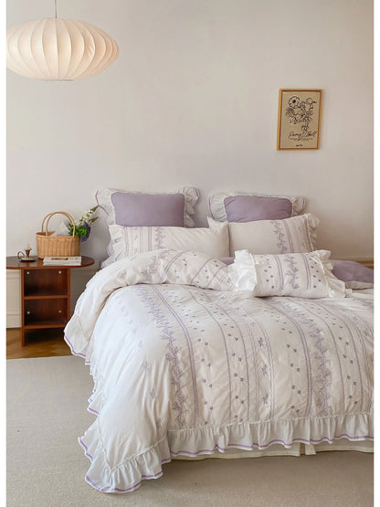 Ruffled Floral Vine Embroidered Cotton Bedding Set in Lavender, styled in a bright, airy bedroom. - RoomDen