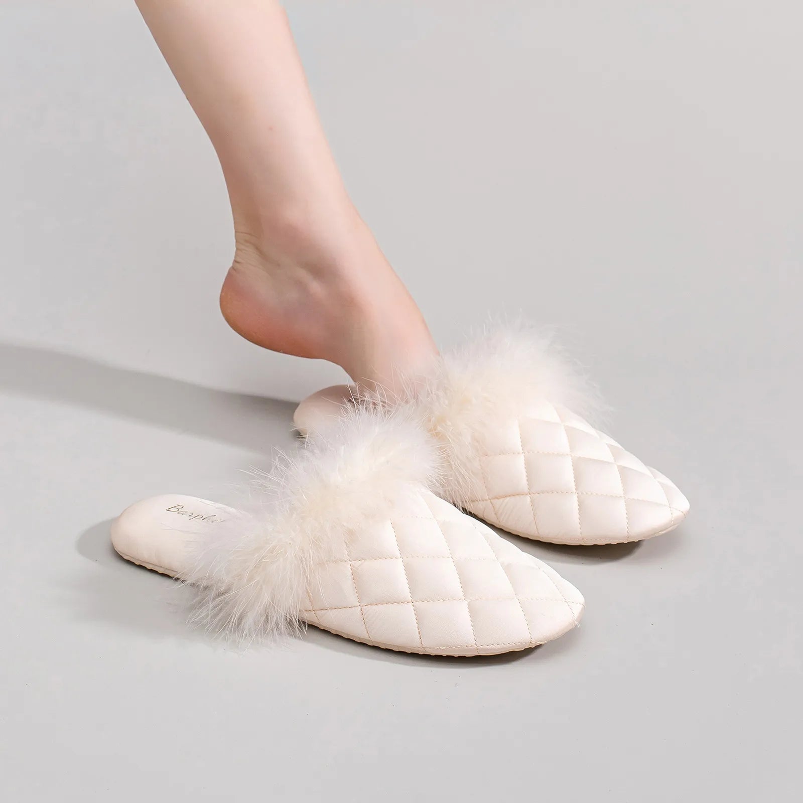 Cream beige quilted slides showing soft texture on legs