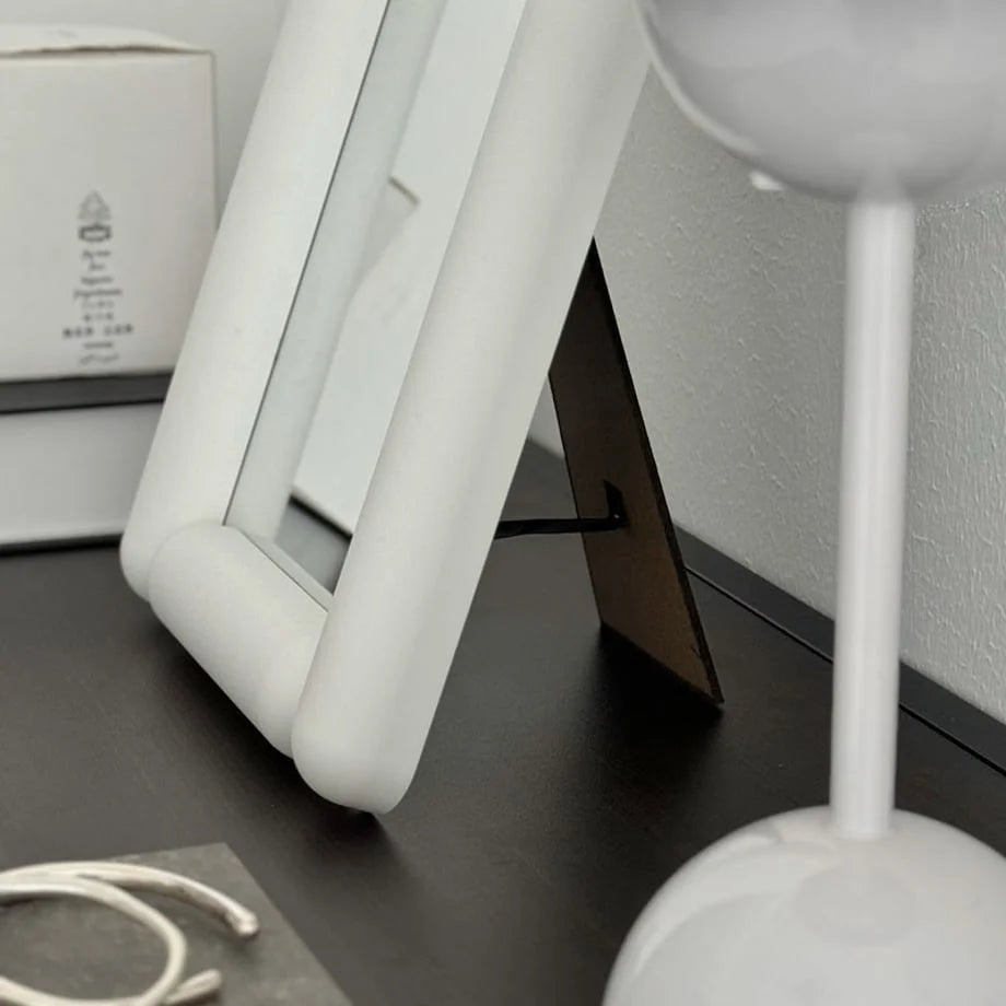 Close-up of the back stand of the white desktop mirror. - RoomDen