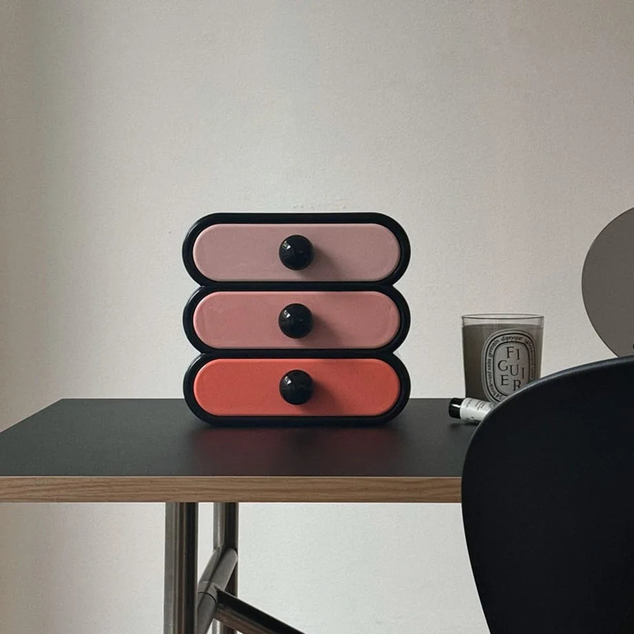 Front-facing view of the black and pink gradient makeup organizer on a desk. - RoomDen