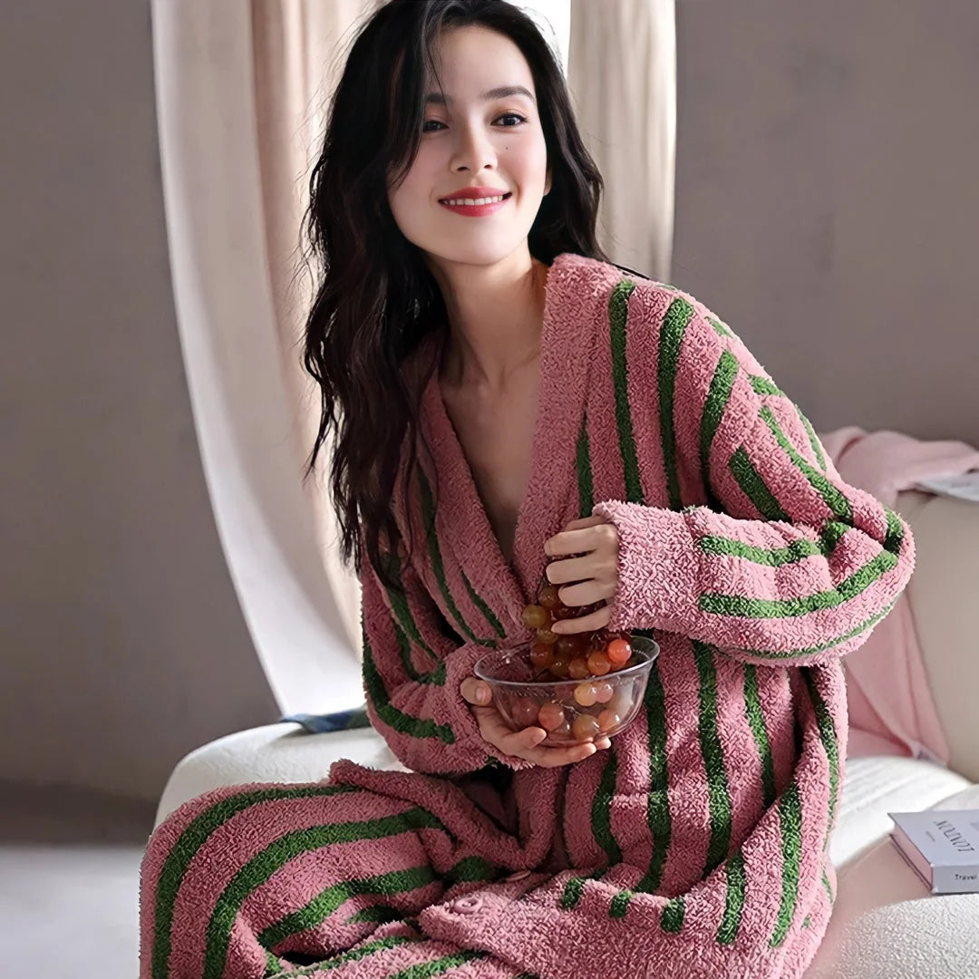 Model wearing the cozy Pink & Green Striped Flannel Fleece Pajama Set while enjoying a snack - RoomDen