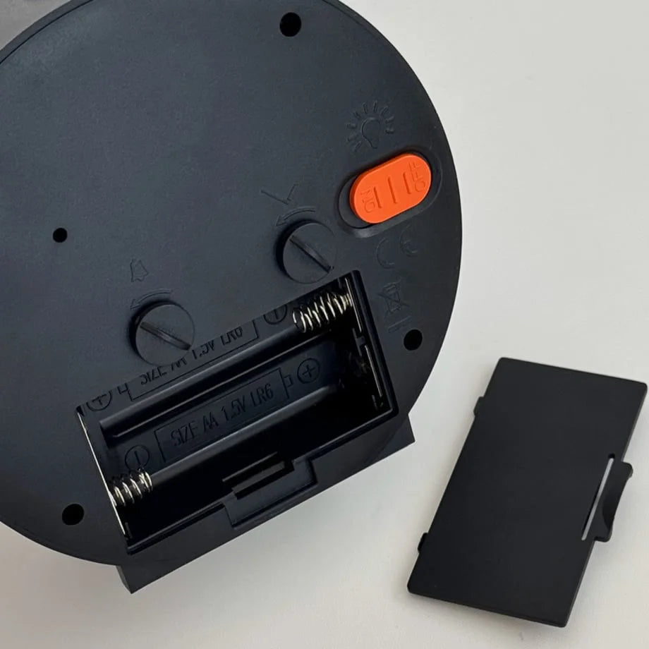 Detailed view of the open battery compartment on the back of the alarm clock, requiring AA batteries. - RoomDen