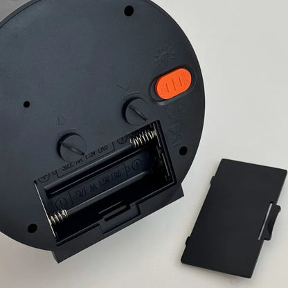 Detailed view of the open battery compartment on the back of the alarm clock, requiring AA batteries. - RoomDen