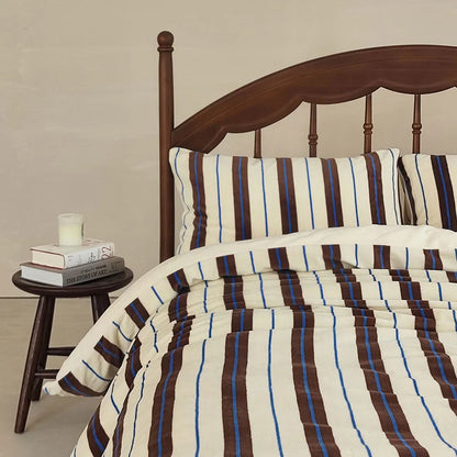 The cream and brown striped velvet bedding set styled in a Light Academia themed room - RoomDen.