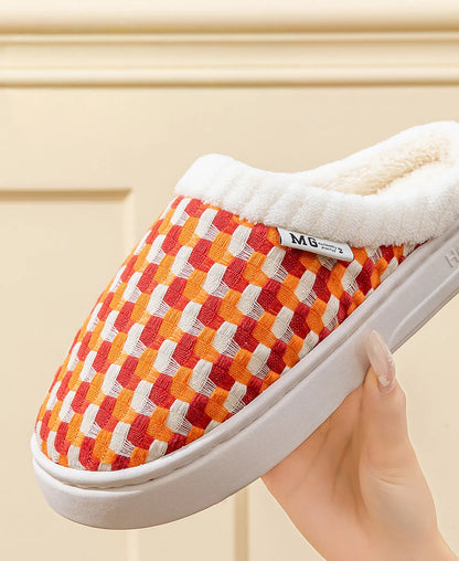Hand holding orange woven plush slipper showing soft texture and thick sole - RoomDen