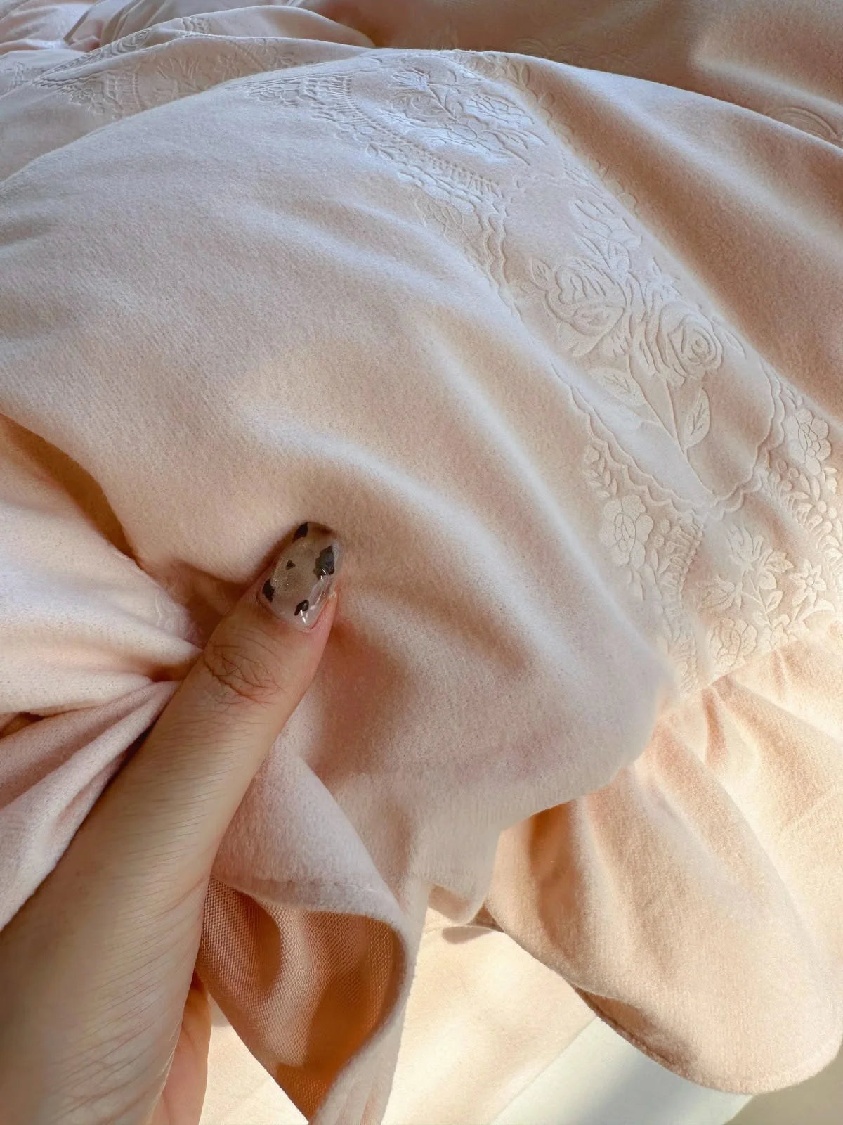 Close-up of the soft Blush Pink velvet fabric, showing the subtle embossed floral pattern. - RoomDen