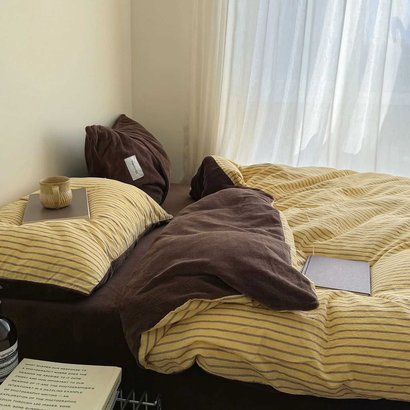 Lifestyle scene of the Brown & Yellow bedding in a sunlit room with sheer curtains.
