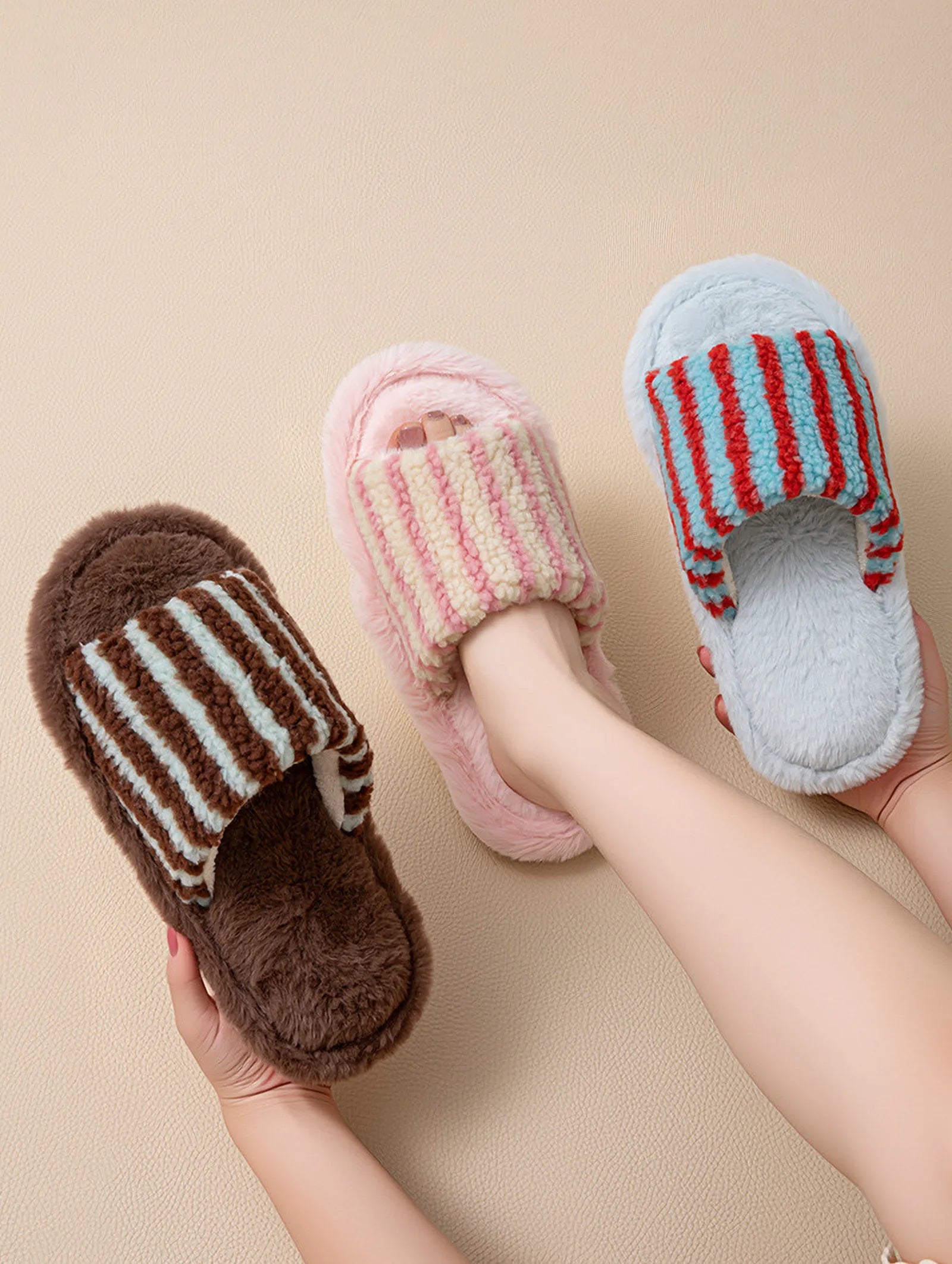 Hand holding Brown and Blue striped slipper with other colorways in background - RoomDen