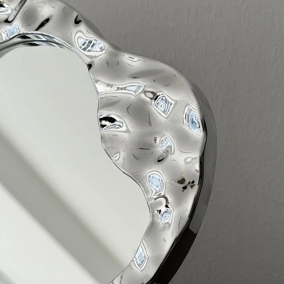 Close-up detail of the molten, textured chrome frame of the Y2K-style desktop mirror - RoomDen