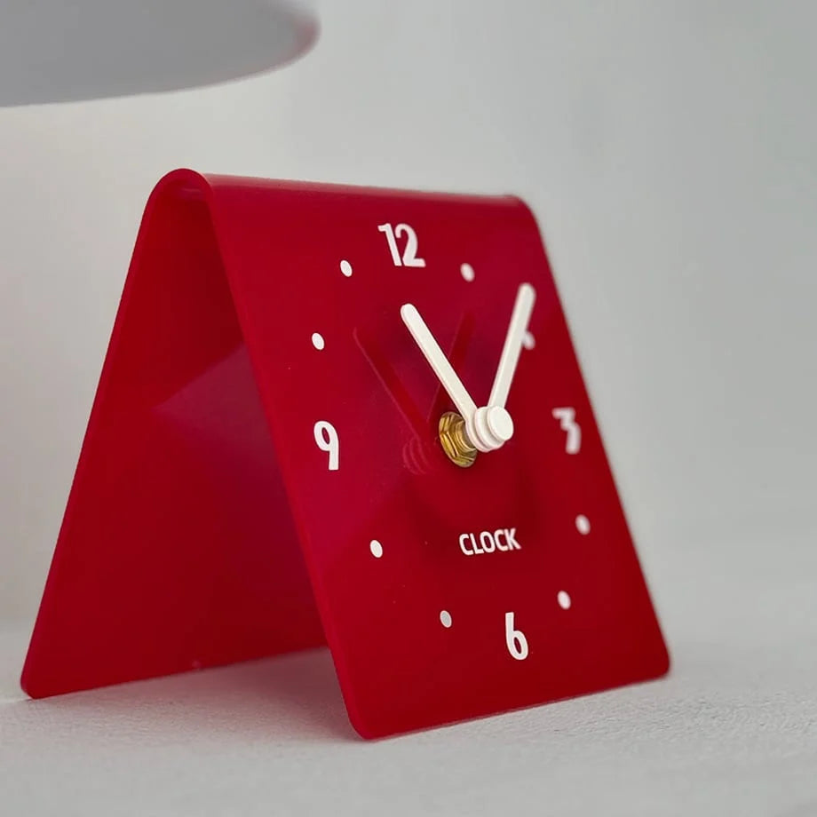 Detailed shot of the red table clock's face with white hands and markers. - RoomDen