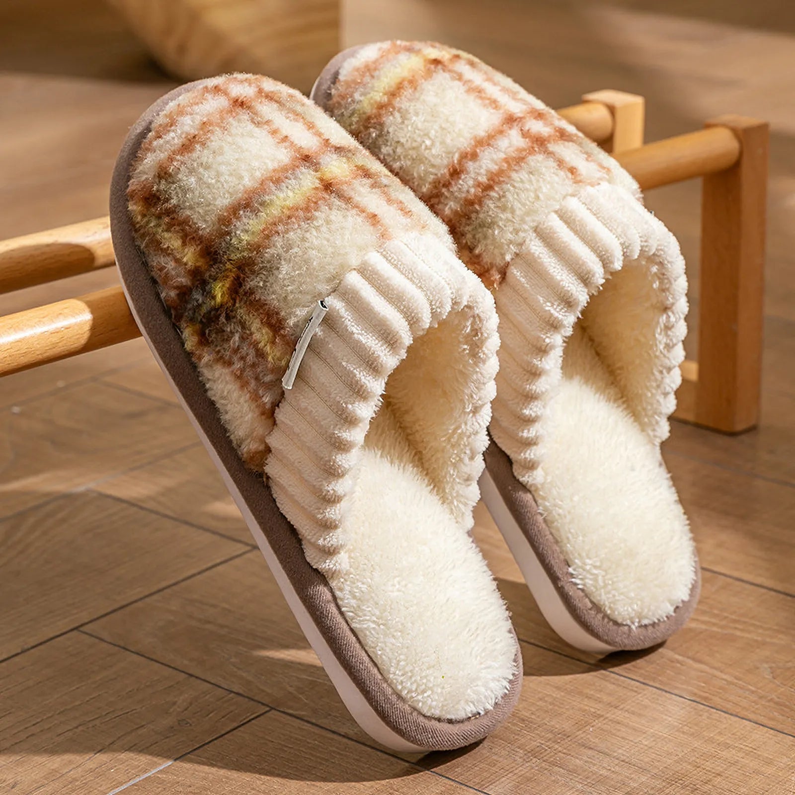 Brown and cream plaid sherpa slippers leaning against a wooden rack showing knit cuff detail - RoomDen
