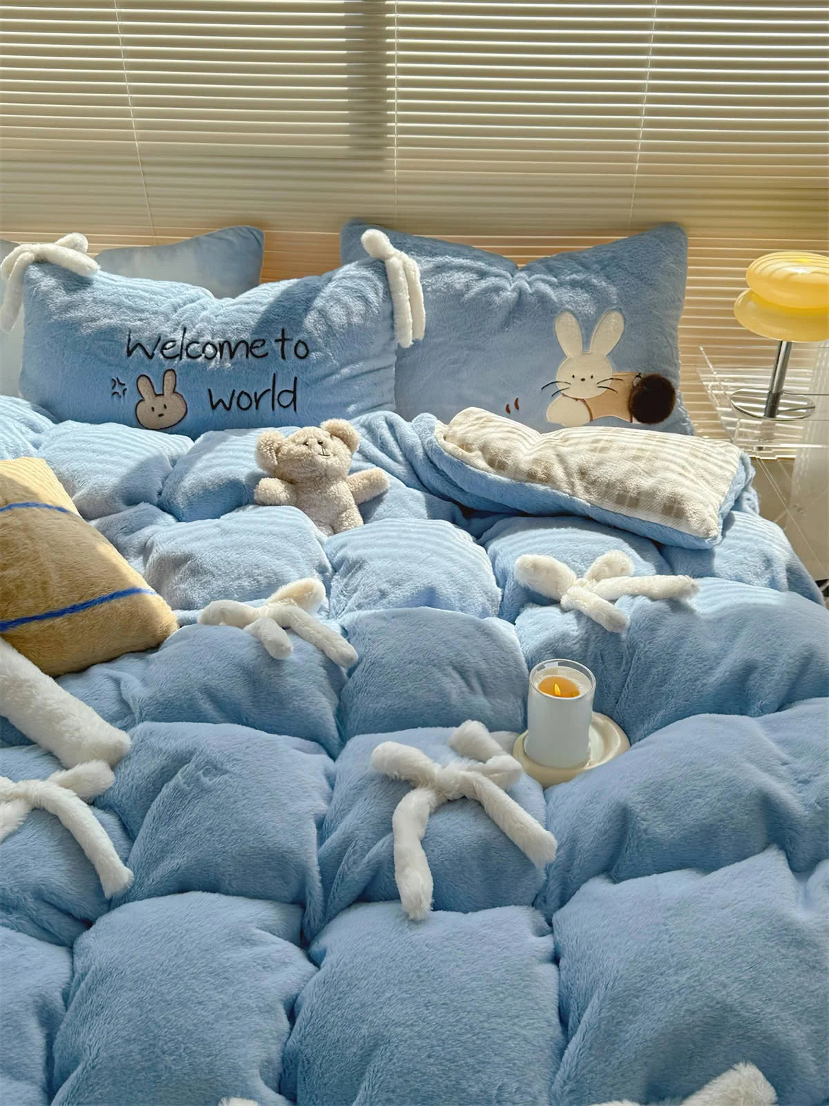 Close-up of the Baby Blue Bunny bedding set showing the plush texture and embroidered pillow. - RoomDen