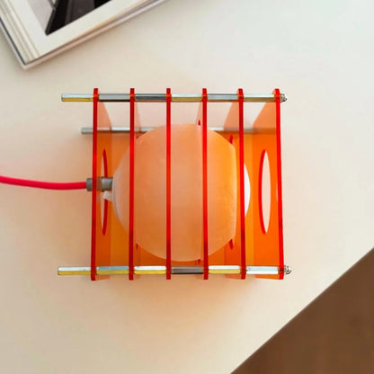 Top-down view of the Sunset Orange Caged Sphere Lamp, showing the inner orb and red elastic bands - RoomDen