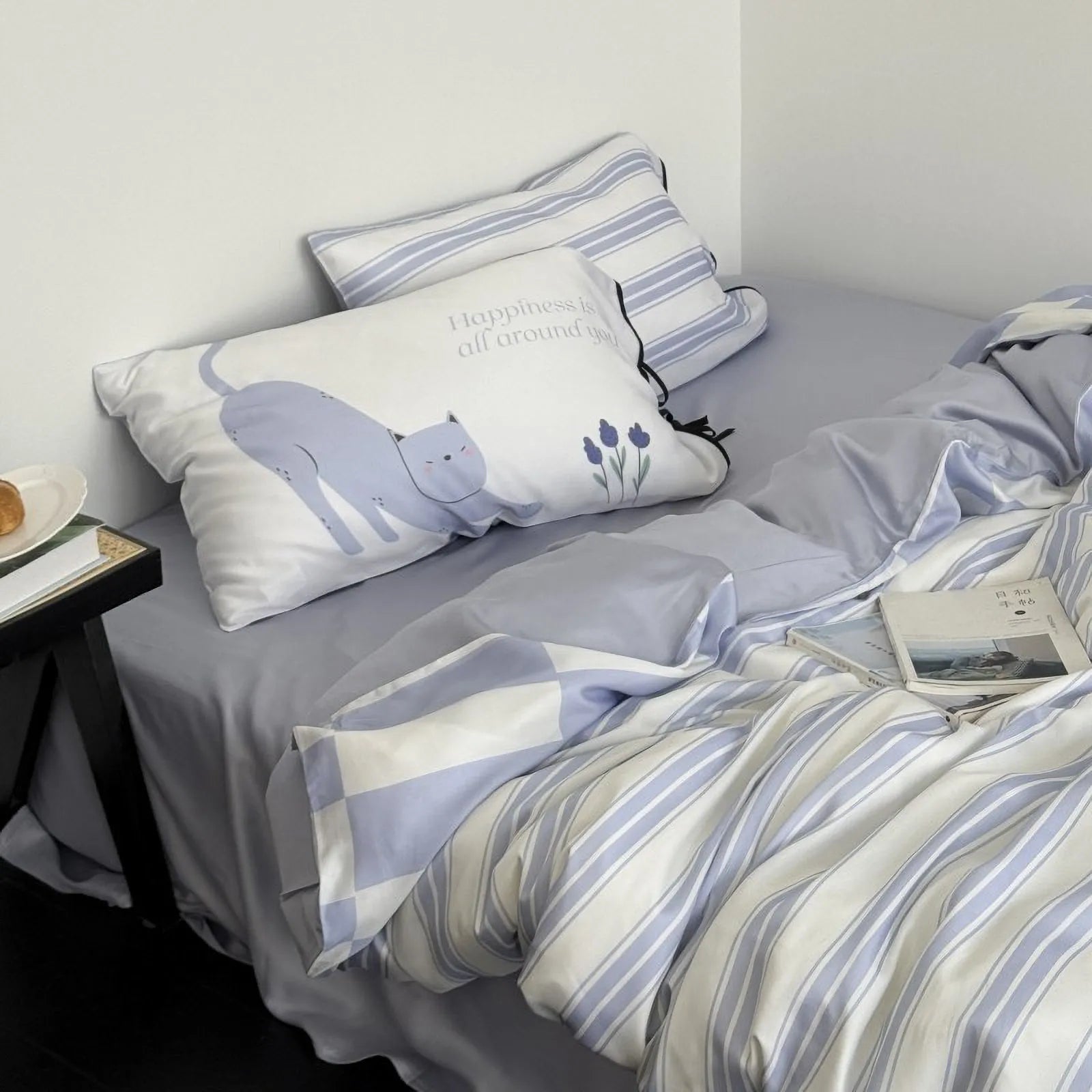 Angled shot of the Cat & Stripe Washed Cotton Bedding Set, highlighting the soft texture and the cute cat pillow. - RoomDen