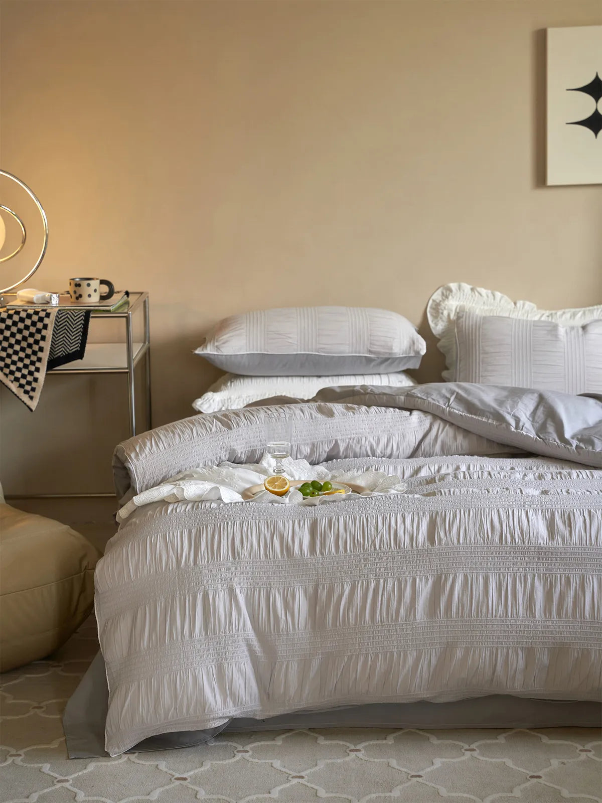 Dove Grey pintuck bedding set in a modern bedroom with warm, neutral walls. - RoomDen