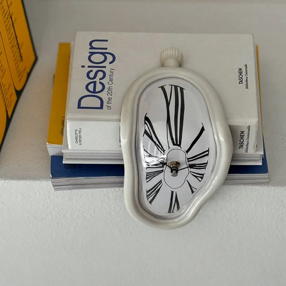 Top-down view of the white Dali-style melting clock on books.
