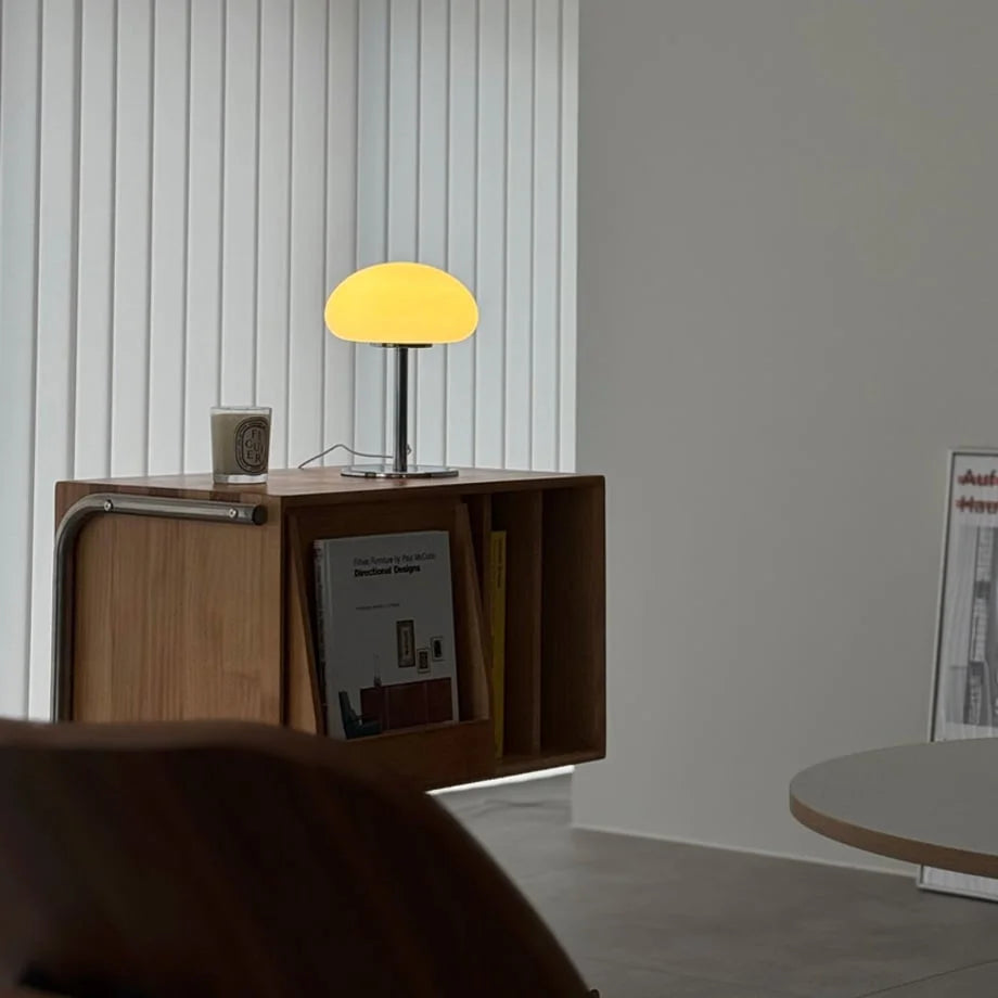 The lit white mushroom lamp creating a cozy ambiance in a minimalist room - RoomDen.