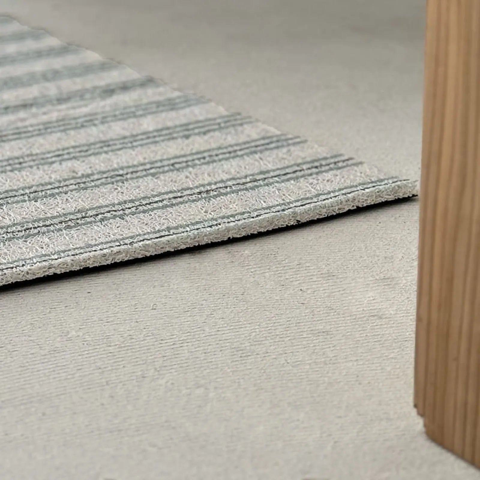 Low angle close up showing the thickness of the PVC coil rug edge - RoomDen