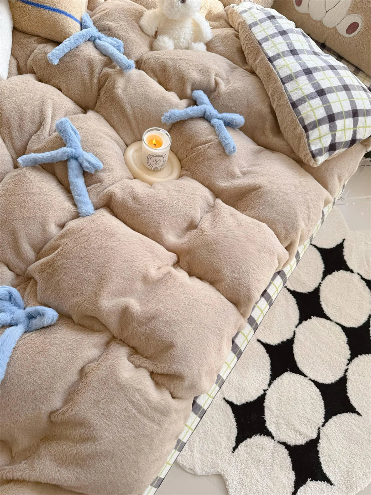 Angled view of the Khaki Brown Bear comforter next to a black and white circular rug.