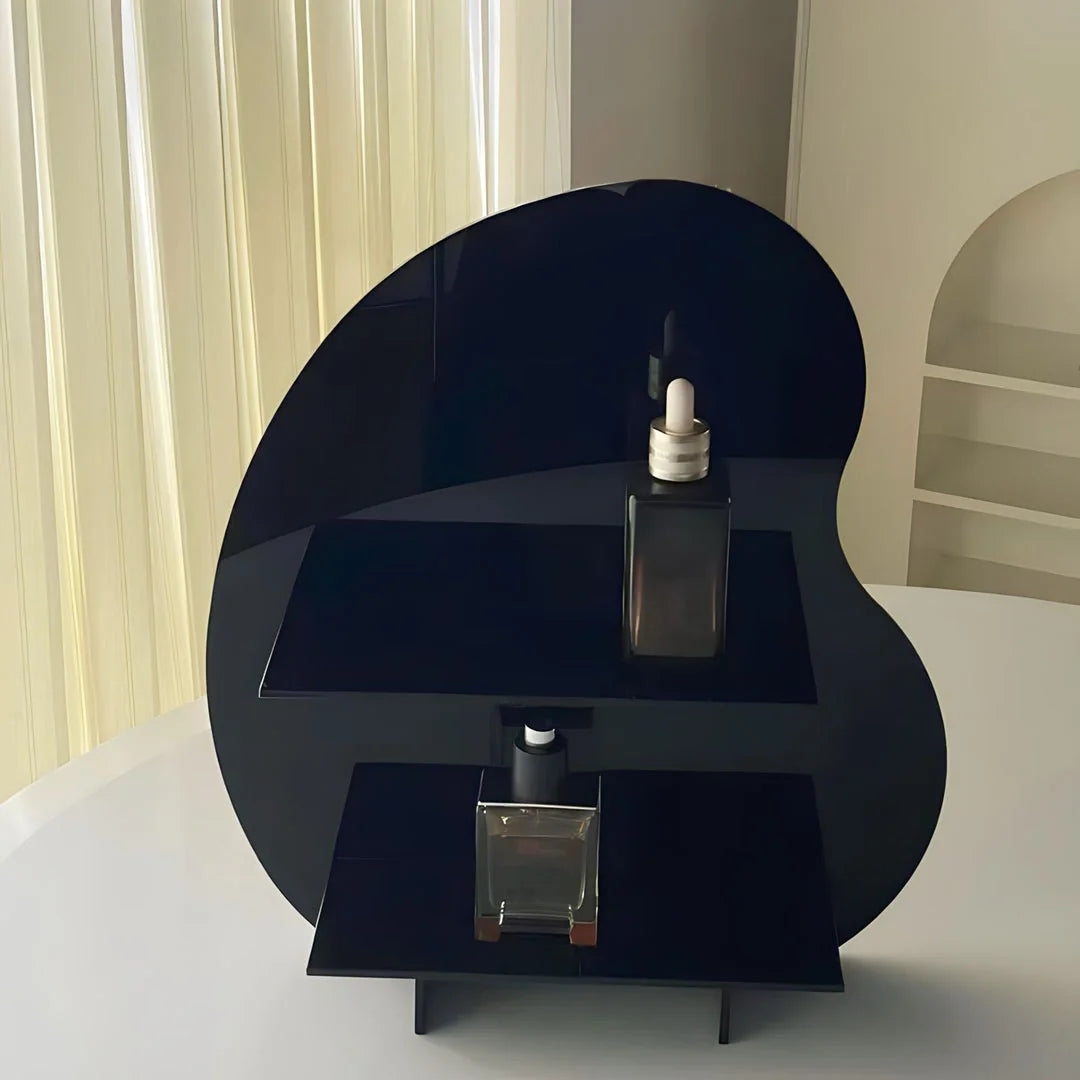 Detail shot of the black wavy acrylic two-tier shelf holding small glass bottles. - RoomDen