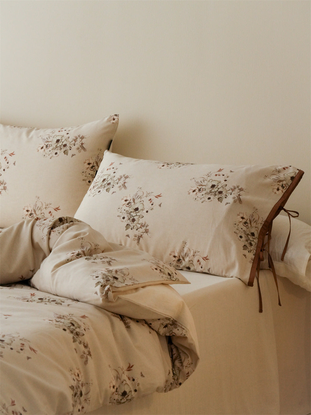 Stillgarden Butterfly Posy Cotton Linen Bedding Set – Pale floral pillows and draped duvet beside a lamp - Roomden