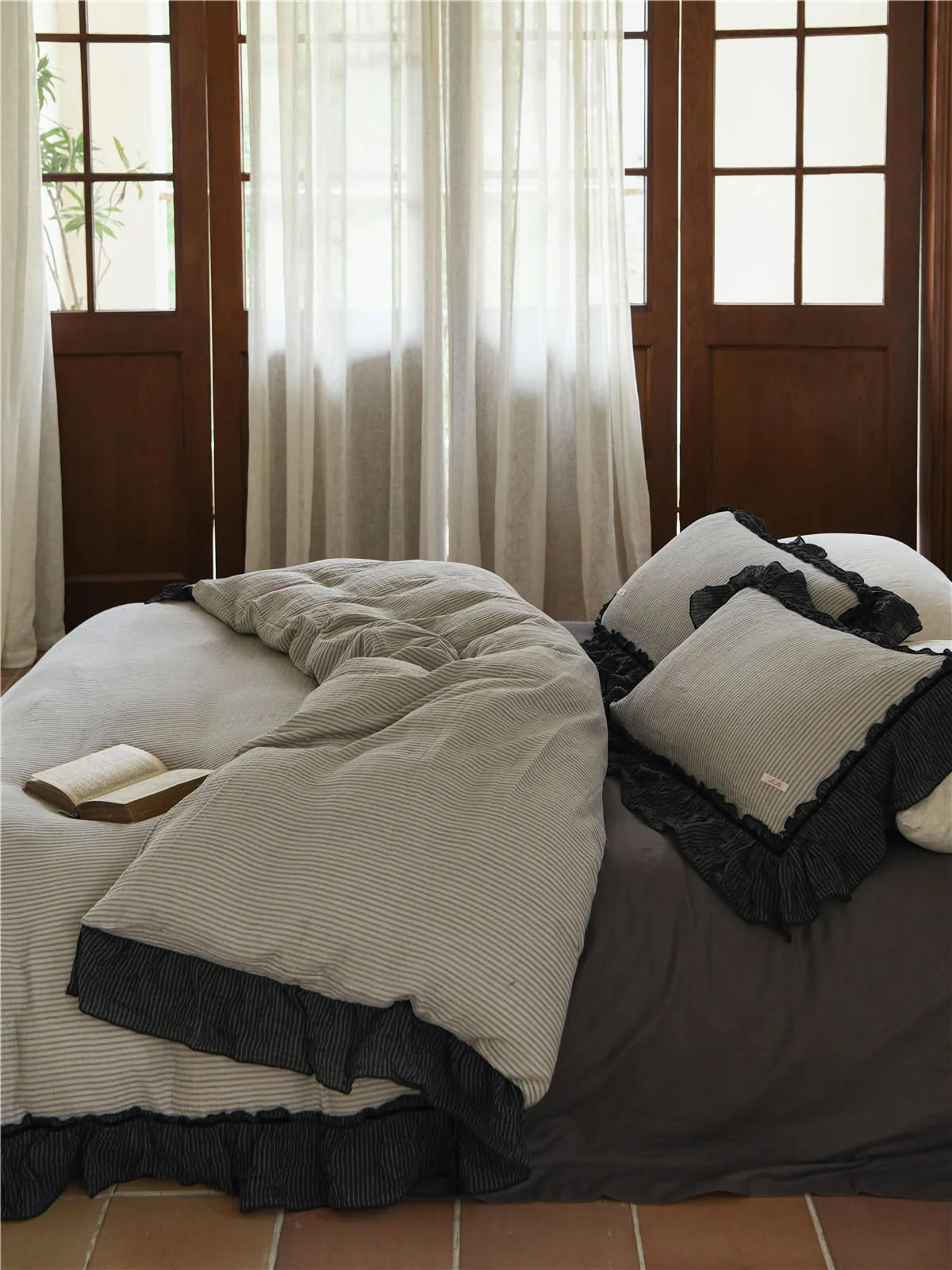 View of the ruffled pinstripe bedding set from the foot of the bed, showing the drape of the fabric. - RoomDen
