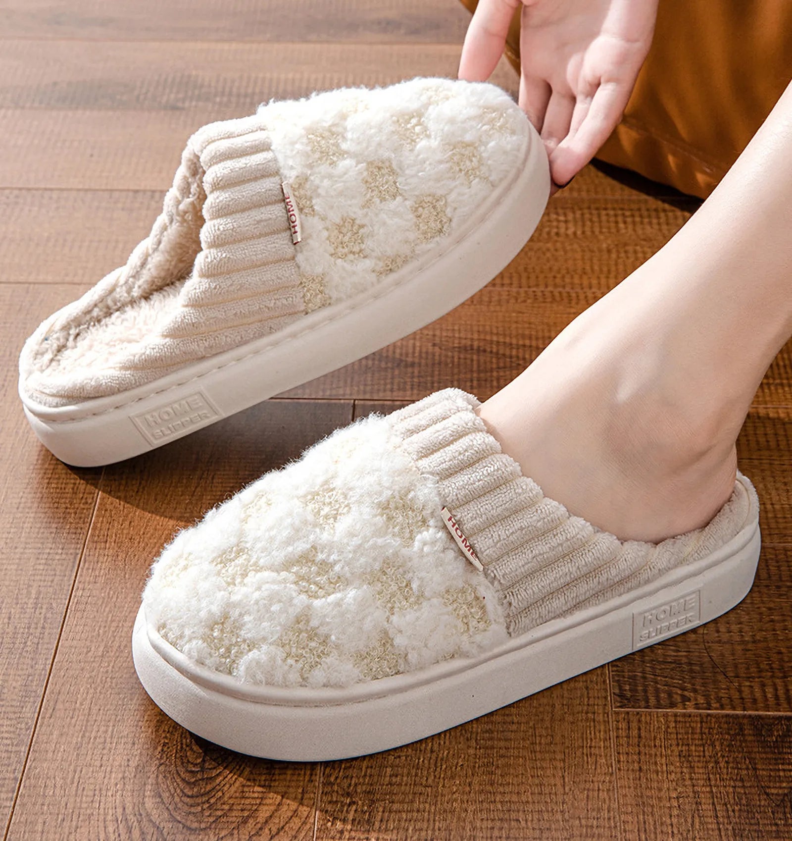 Beige fuzzy checkered slippers on model feet on wooden floor - RoomDen