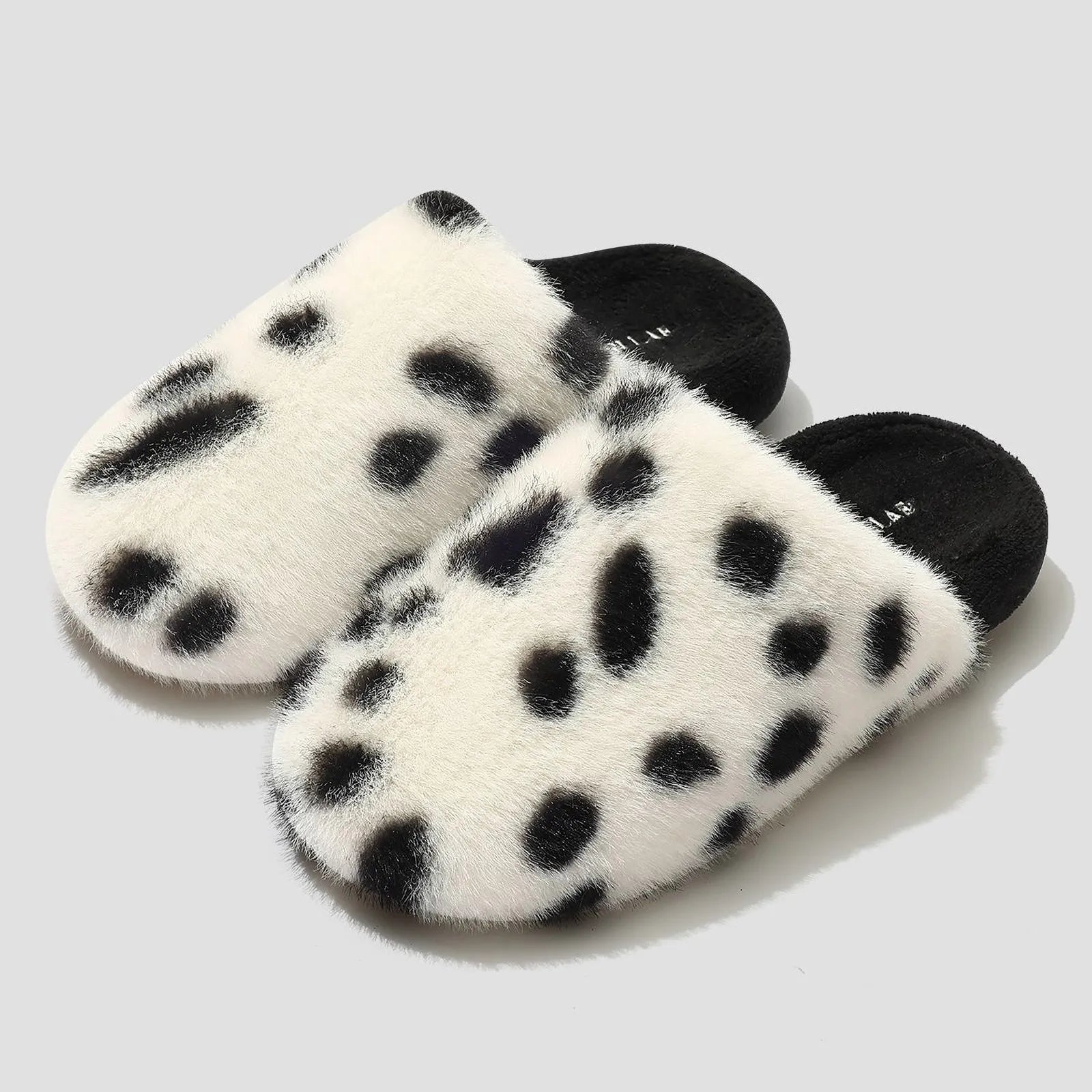 Isolated pair of White & Black Spots cow print plush slippers