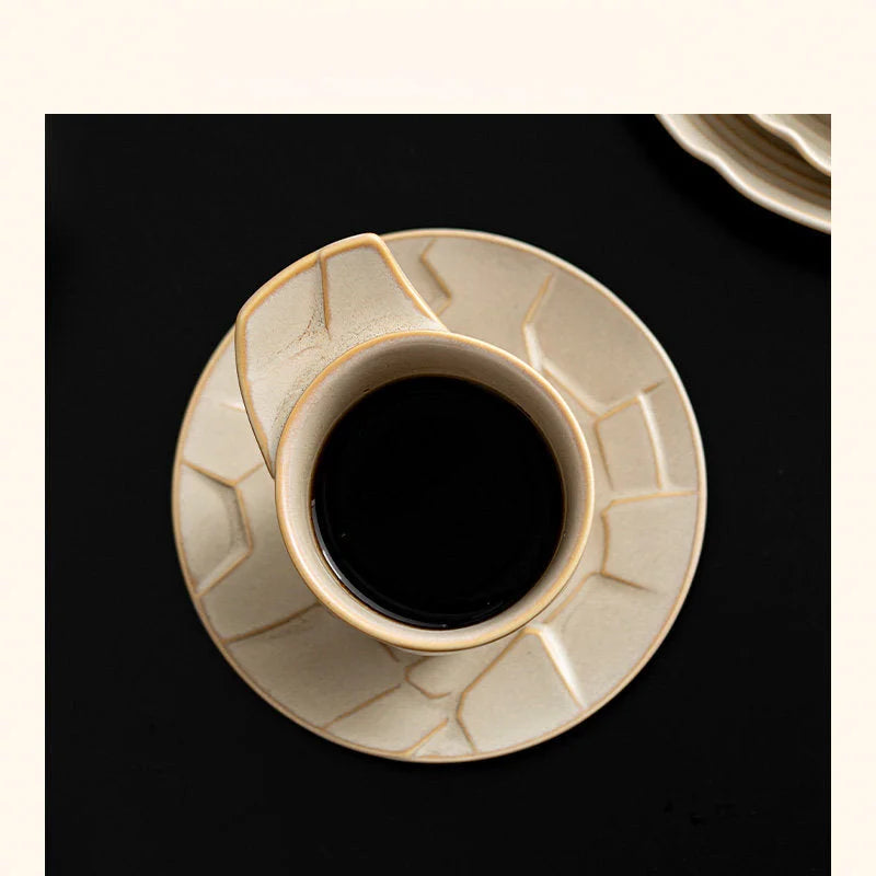 Top view of the Sandstone Beige ceramic cup filled with black coffee, on its matching saucer - RoomDen
