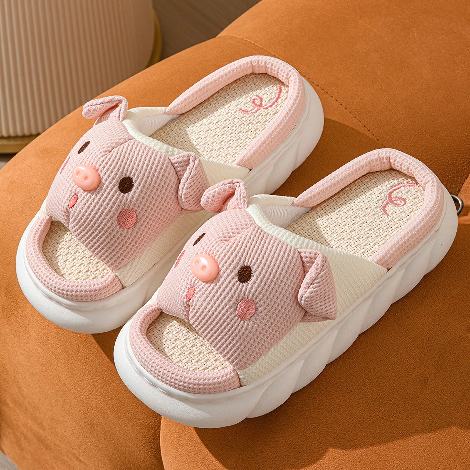 Pair of Pink Waffle Textured Embroidered Pig Linen House Slippers on an orange surface - RoomDen