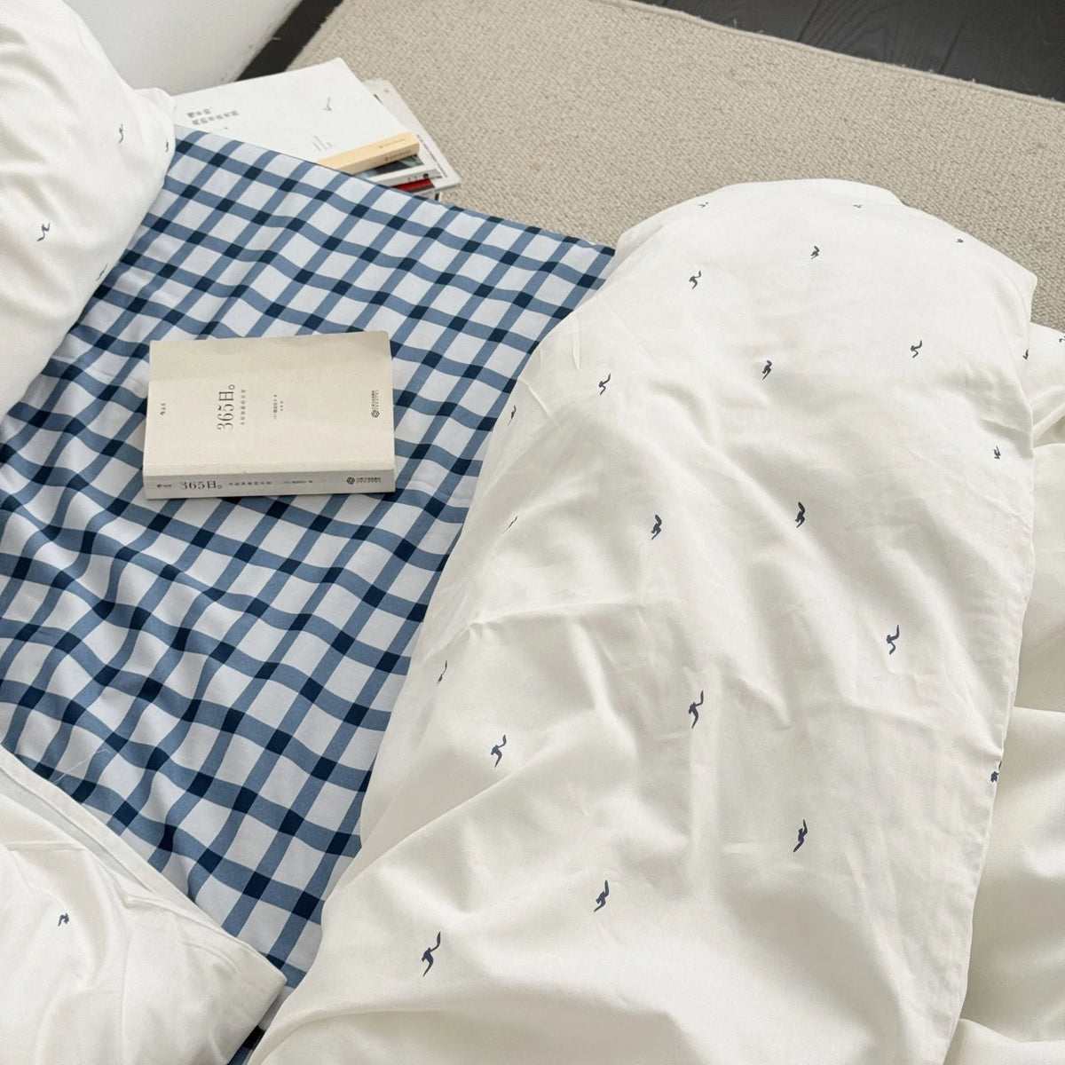 Top-down view showing the contrast between the blue gingham sheet and the white seagull duvet cover - RoomDen