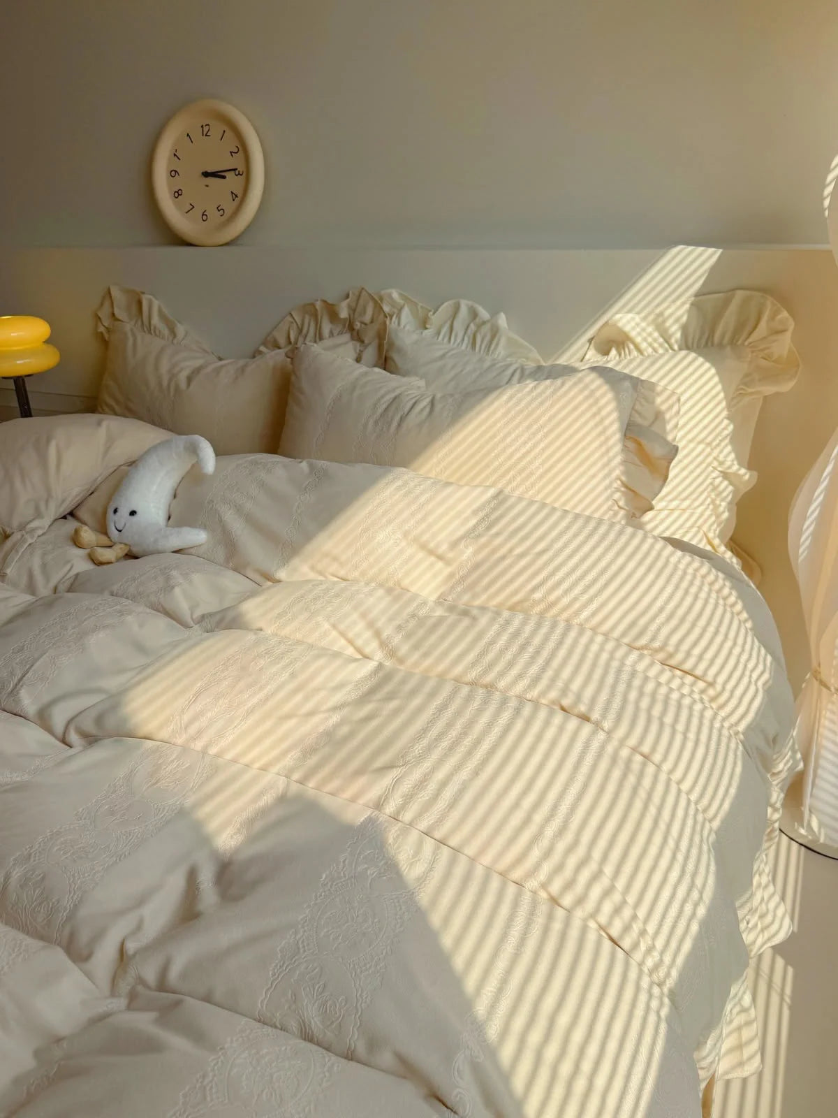 Sunlight casting stripes across the Creamy Beige Ruffled Velvet Bedding Set. - RoomDen