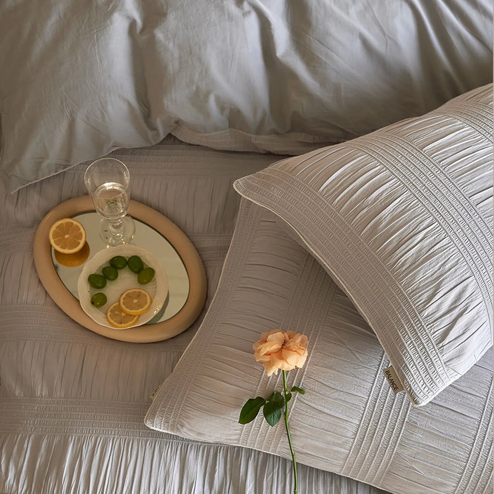Overhead shot of the Dove Grey pintuck pillowcases with a single rose.