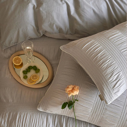 Overhead shot of the Dove Grey pintuck pillowcases with a single rose.