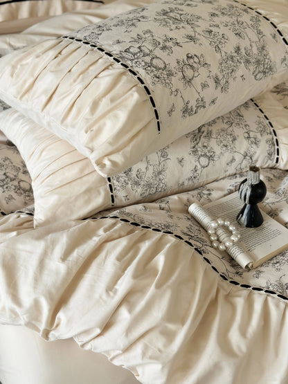 Close-up of the ruched pillows on the Cream Toile bedding, with a book and pearls for a vintage touch. - RoomDen