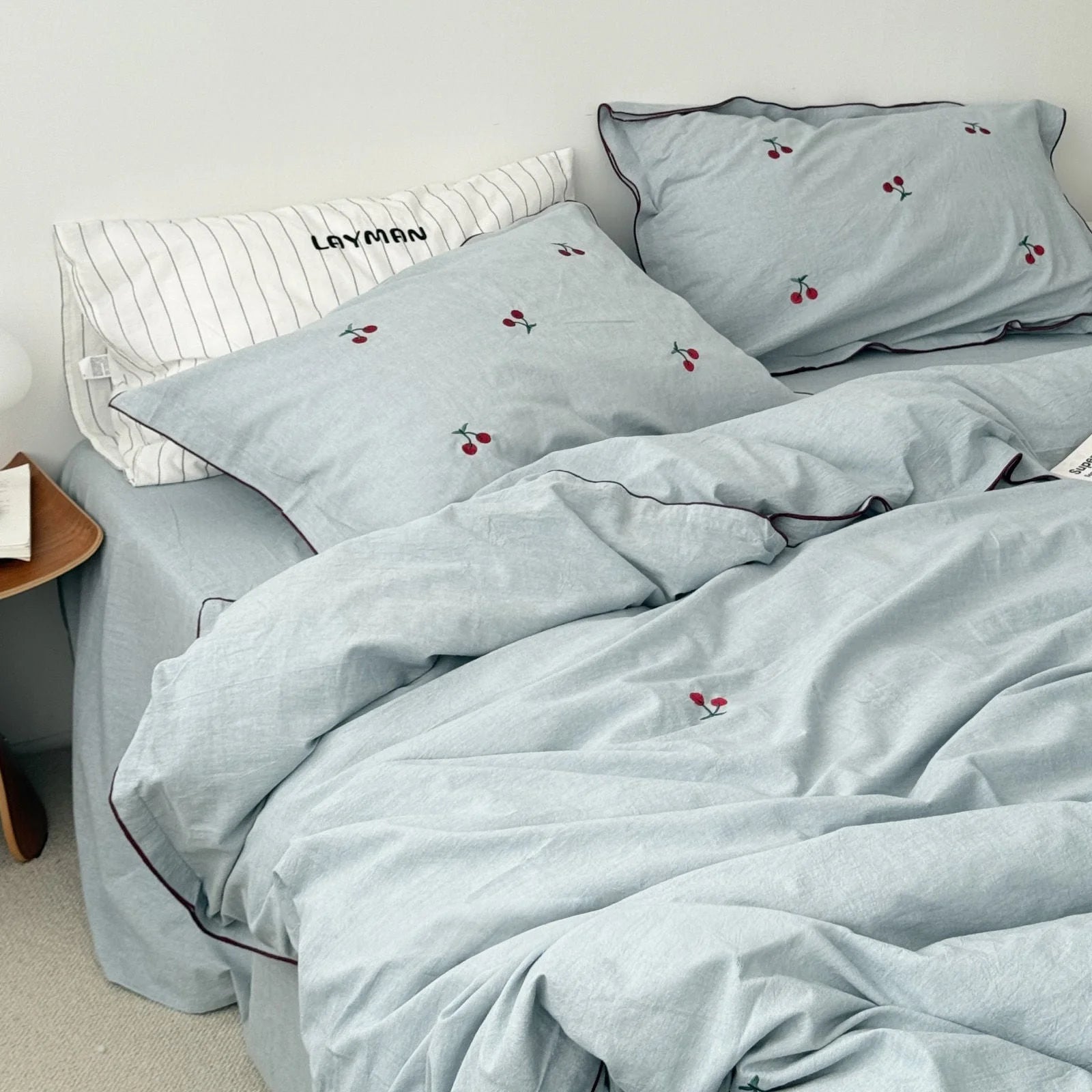 Dusty blue version of the Embroidered Cherry Washed Cotton Bedding Set on a bed.