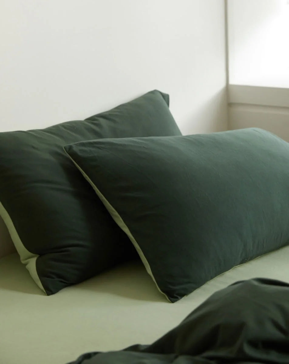 Soft Focus Shot of Forest & Sage Green Pillows against White Wall - RoomDen