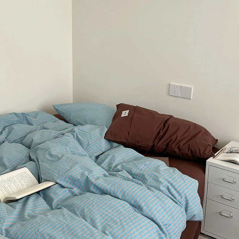 Full bed view of the Blue & Brown Striped duvet set in a simple, well-lit room - RoomDen.