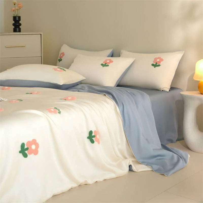 Angled view of the White & Sky Blue Tencel bedding set, showing the texture of the tufted flowers. - RoomDen