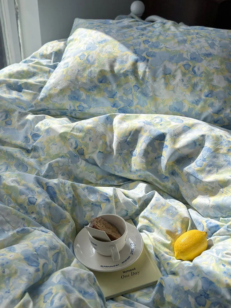Close-up on the washed cotton floral duvet cover, with a cup of tea and a lemon adding to the cozy scene.