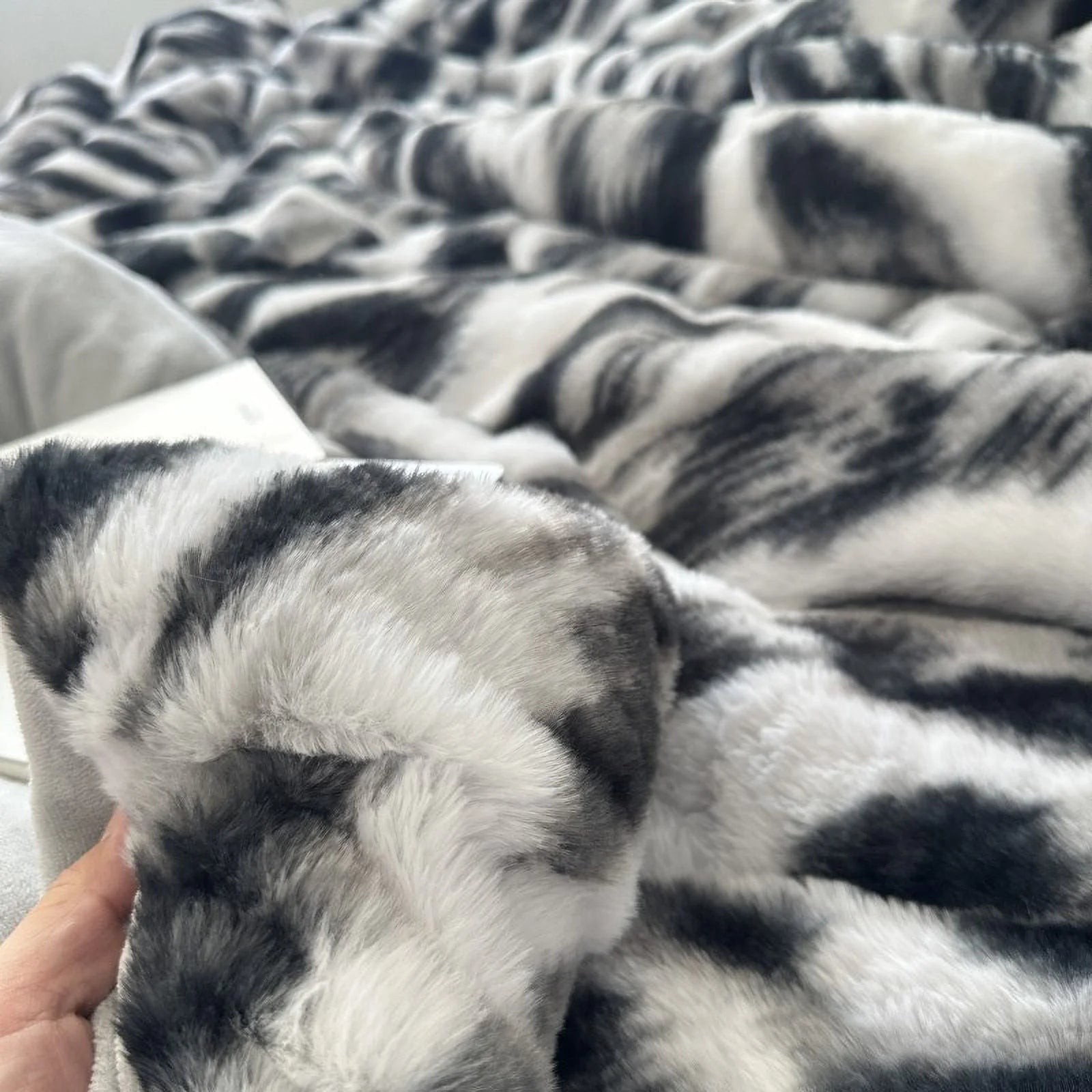 A hand holding the corner of the plush flannel fleece duvet, highlighting its thick and soft material. - RoomDen