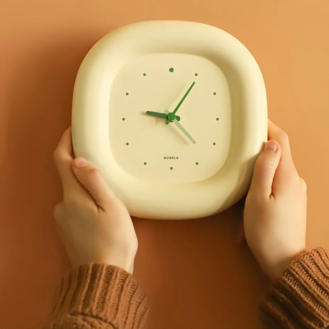 Close-up of a person holding the Creamy Beige Puffy Bubble Table Clock with green hands - RoomDen