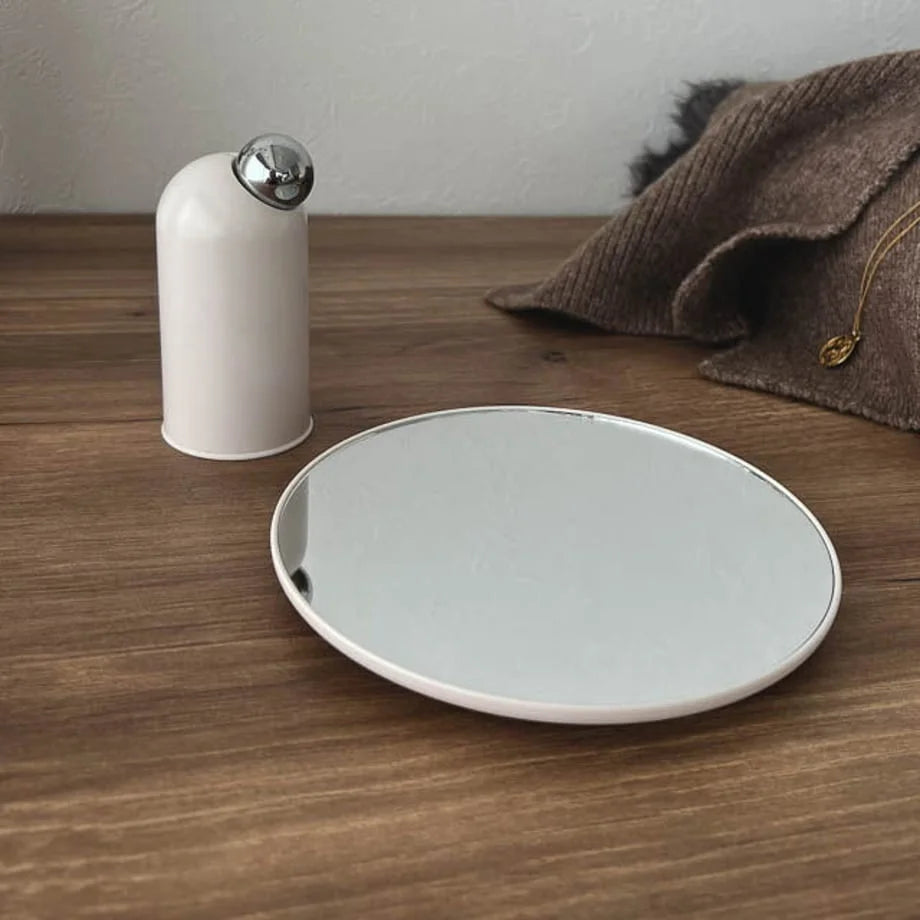 The two components of the white desktop mirror, base and mirror, separated.