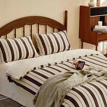 Full view of the cream, brown, and blue striped velvet bedding set in a cozy bedroom setting - RoomDen.